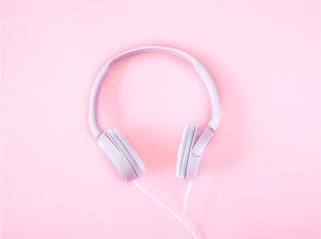 Soft pastel pink background with pink headphones