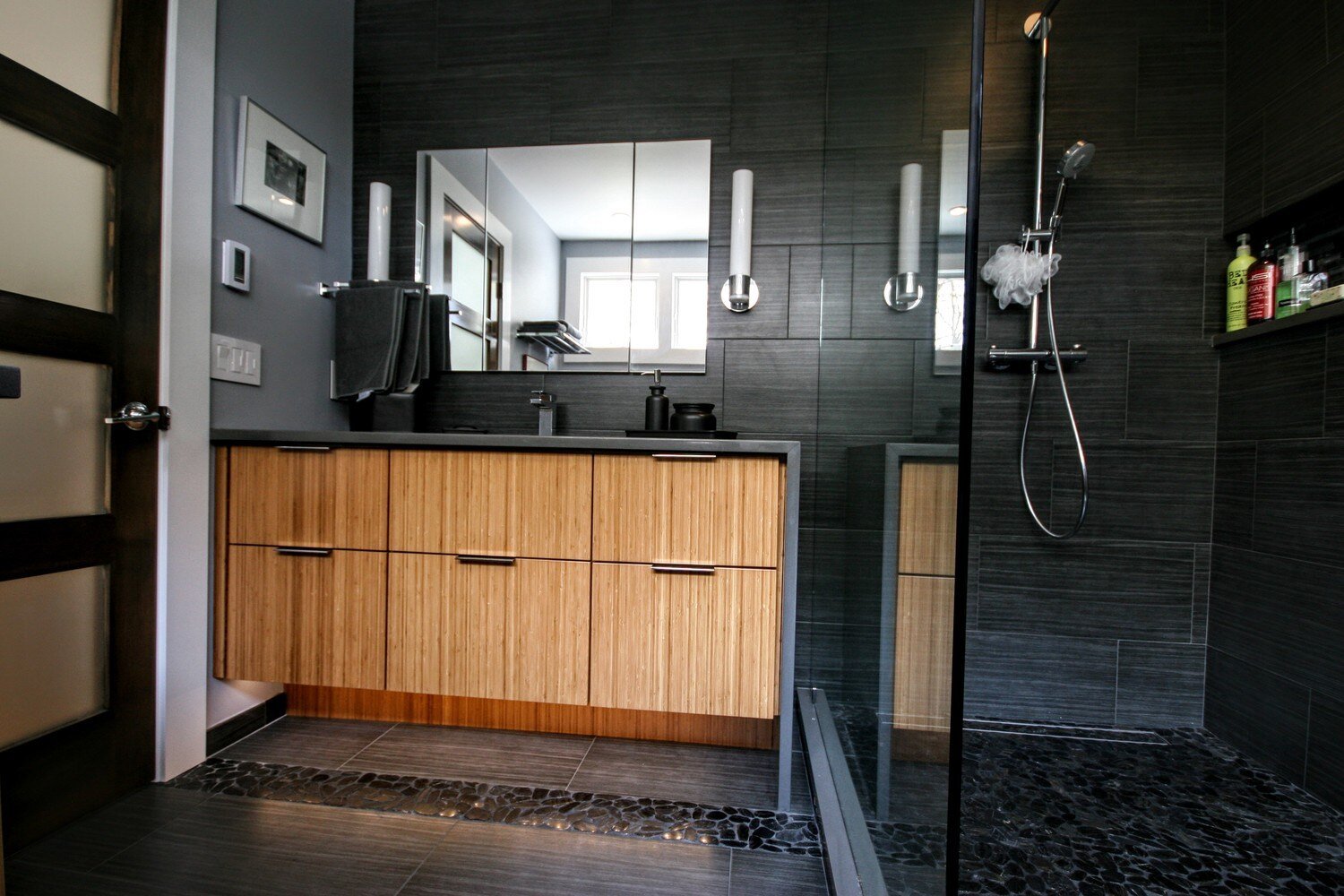 Elegant bathroom featuring wood vanity and sleek dark tiles in Mashpee remodel