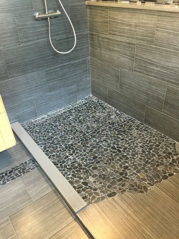 Stylish pebble stone shower floor in Mashpee home bathroom renovation