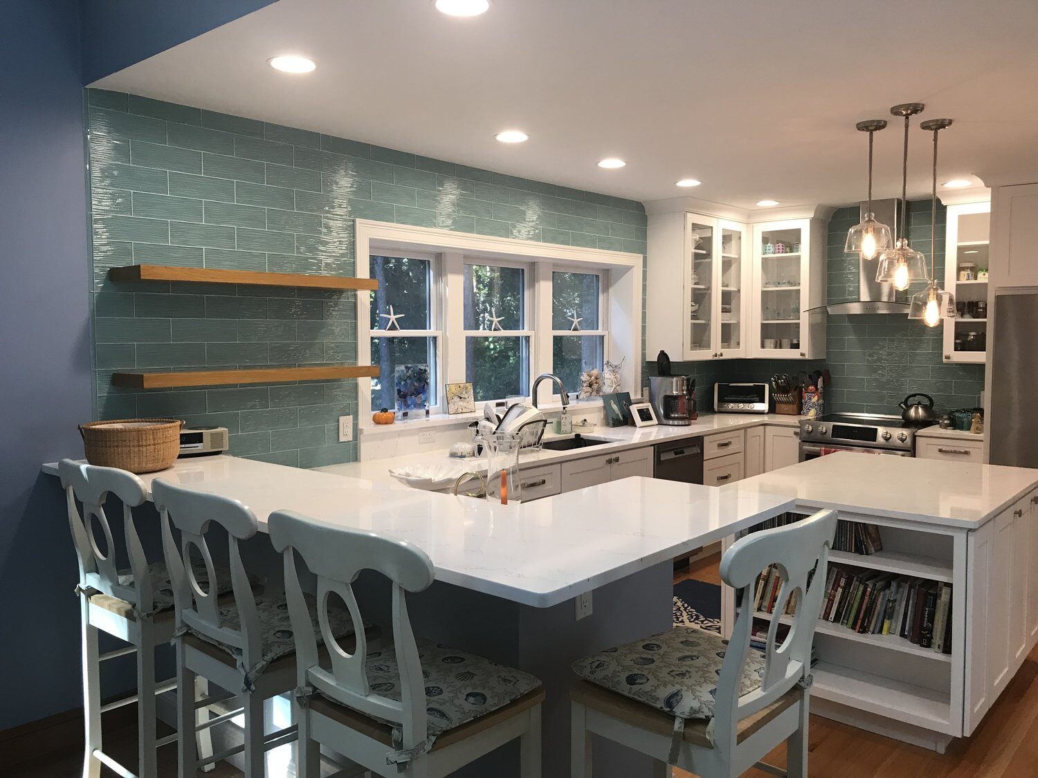 Custom kitchen renovation in Mashpee featuring a white island and teal backsplash by At Design Remodel