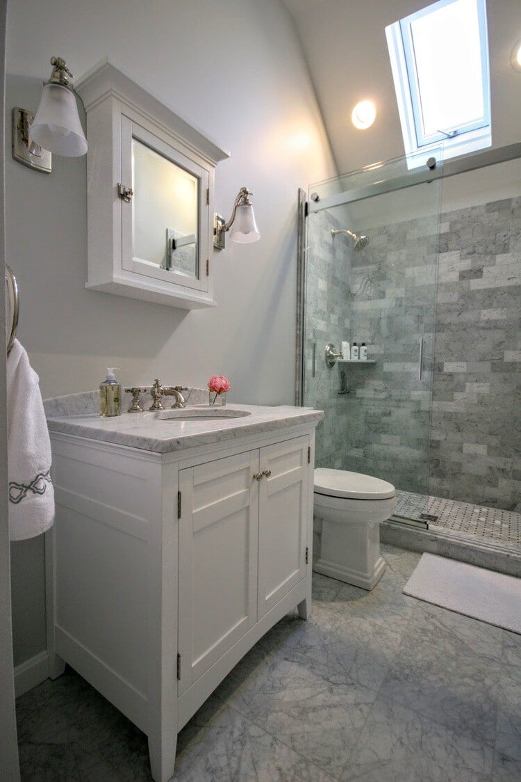 Modern bathroom with marble vanity and glass-enclosed shower in New Seabury Mews condo, remodeled by At Design Remodel