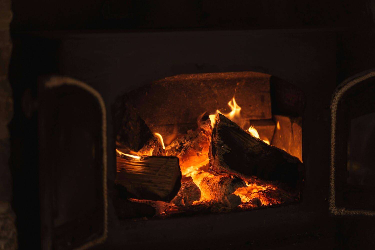 A fire lit fireplace with people discussing about their next kitchen remodel