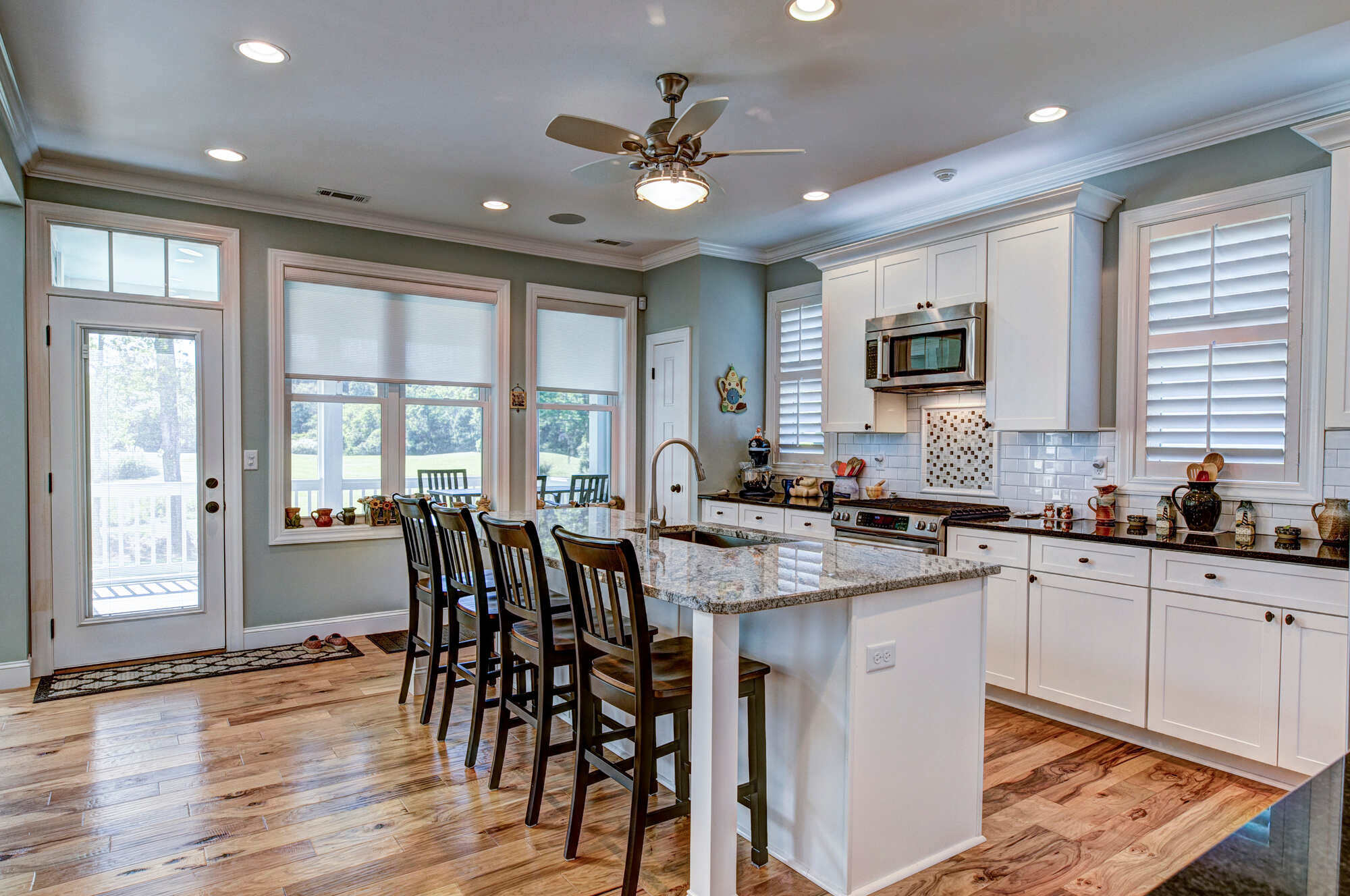 Warm kitchen interior with wood flooring and large island, Cape Cod, MA, by @designREMODEL