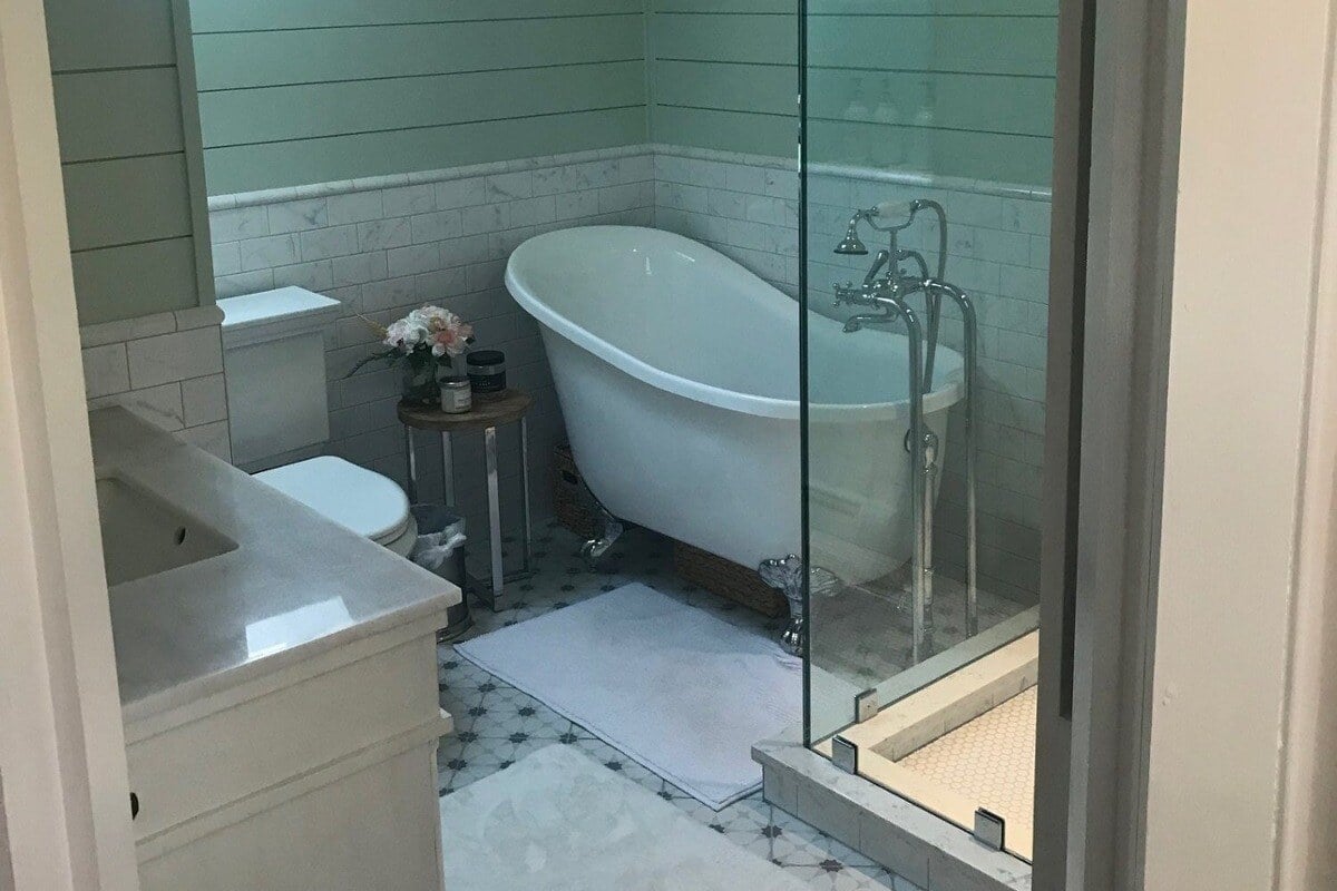 Charming bathroom with a clawfoot tub and skylight in a Cape Cod home remodeled by @designREMODE-1