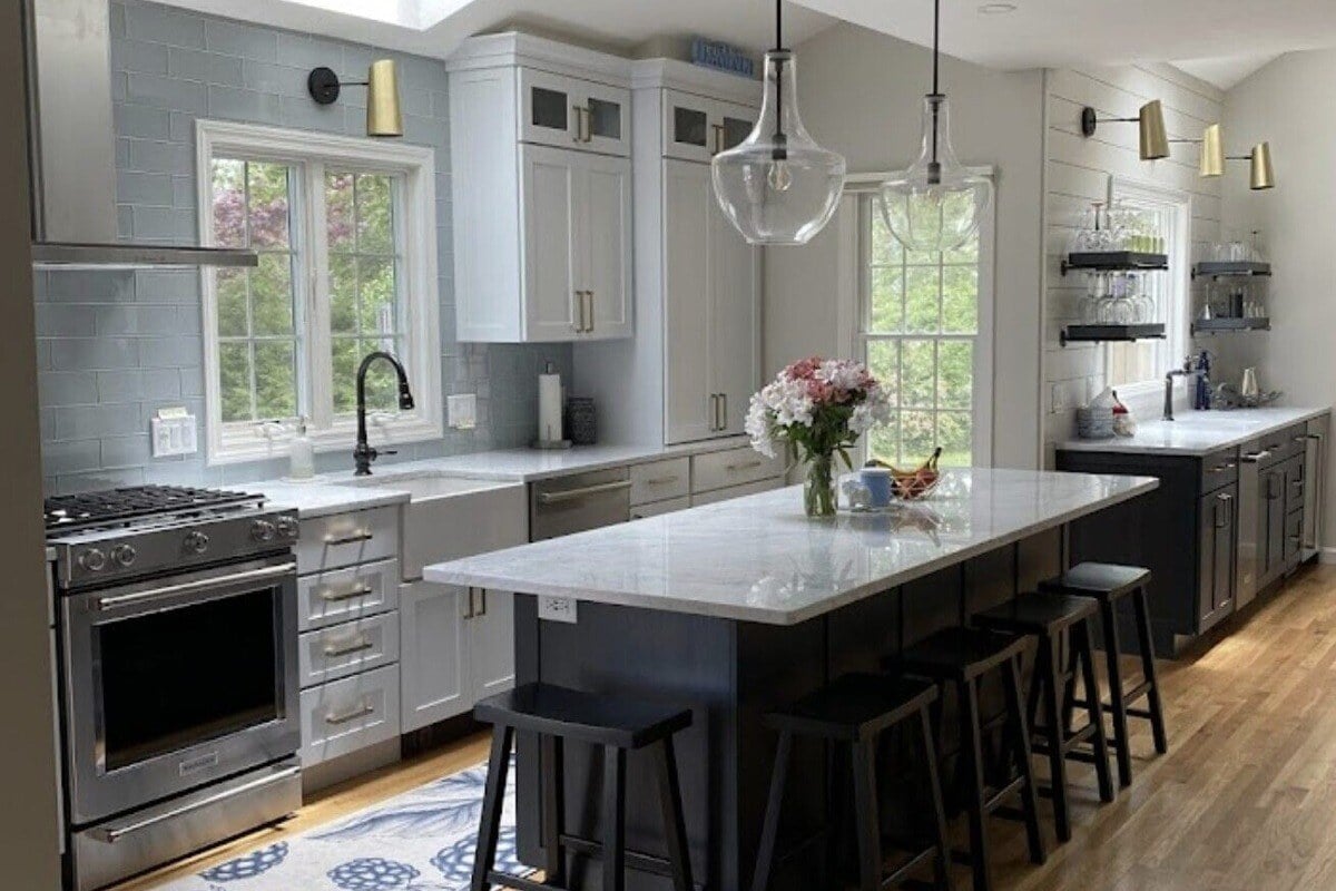 Spacious Cape Cod kitchen with skylights, an island, and modern cabinetry, remodeled by @designREMODEL-1