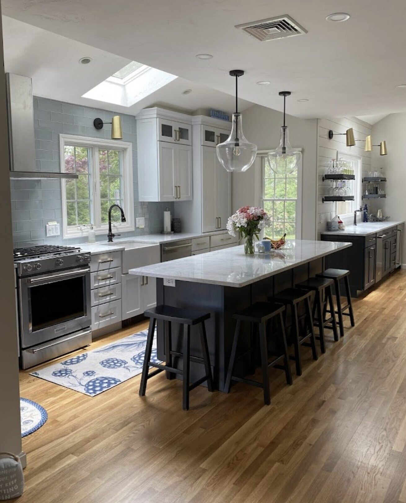 Spacious Cape Cod kitchen with skylights, an island, and modern cabinetry, remodeled by @designREMODEL