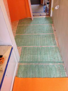 Warmly Yours floor heat installed. Now dry fitting Ditra. (Orange layer) on top